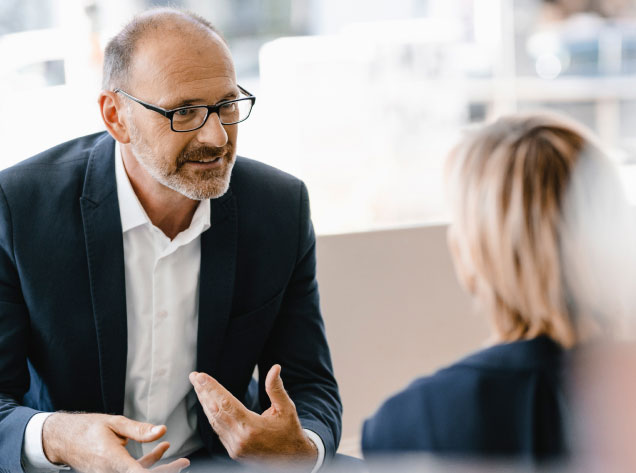 Man talking to a women between a desk